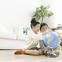 地球儀を見ている姉弟