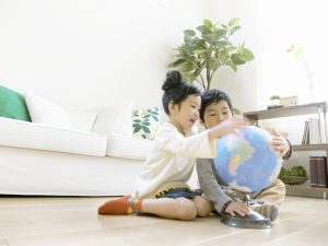 地球儀を見ている姉弟