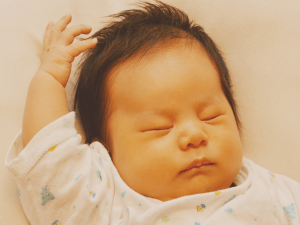 片手をあげる赤ちゃん